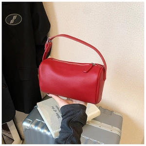 Détail du sac polochon en cuir rouge grainé avec fermeture éclair métallique