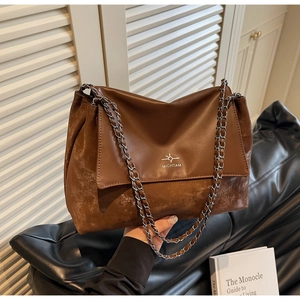 Close-up of vintage brown tote bag featuring mixed leather texture and silver chain strap