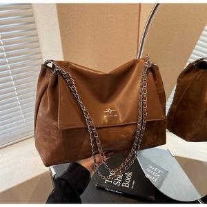 Close-up of vintage brown leather chain bag featuring Michtam logo and textured finish