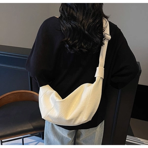 Rear view of cream large dumpling crossbody bag showing wide strap and pleat texture