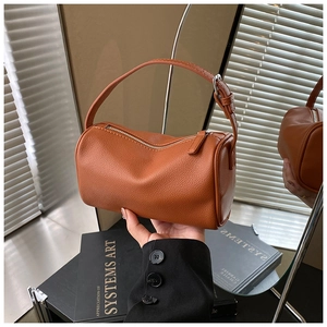 Détail du sac en cuir grainé marron caramel avec bandoulière réglable et fermeture éclair