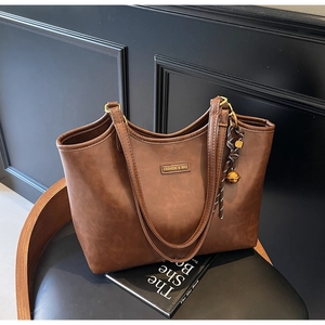Detailaufnahme der braunen PU-Leder-Einkaufstasche mit Vintage-Struktur und Metalllogo