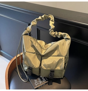Olive green nylon tote bag featuring ruched handles and front pockets with buckle closures