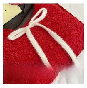 Detail of red plush tote bag with a soft white faux fur bow texture and stitching