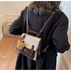 Details des Vintage-Rucksacks aus Leder in Beige und Braun mit süßem Bärenanhänger