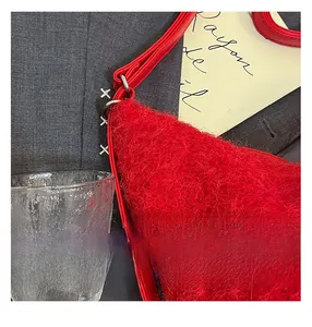Detailed macro view of the fluffy red plush texture and leather strap on this tote bag