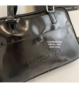 Detail of glossy black leather tote bag with silver buckle and Noronoro embossed logo