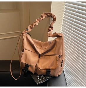 Detail of khaki tote bag featuring pleated cloud straps and large utility cargo pockets