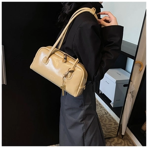 Detail of khaki patent leather bowling bag with glossy finish and brand logo embossing