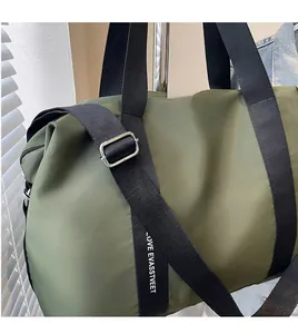 Gros plan du sac en nylon vert armée avec bandoulière réglable et impression de lettres
