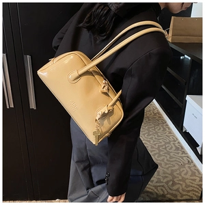 Detail of the glossy khaki patent leather texture with gold zipper and padlock charm