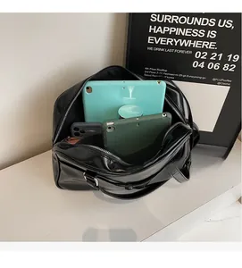 Interior view showing the large capacity of a black glossy tote bag with multiple tablets