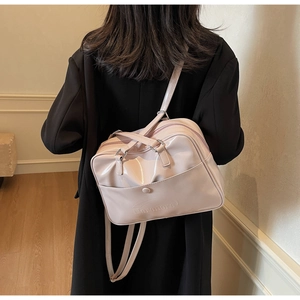 Detail of adjustable straps and glossy patent leather on this versatile pink backpack
