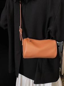 Sac cylindrique orange à texture litchi avec bandoulière réglable pour femme élégante