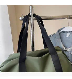 Détail du sac de voyage en nylon vert armée avec poignées noires renforcées et coutures