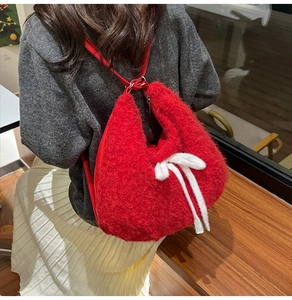 Detailed view of red plush faux fur backpack with a white decorative bow on model