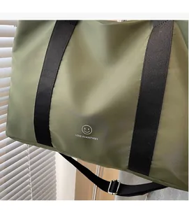 Vue détaillée du sac cabas en nylon vert olive avec sangles noires et motif sourire