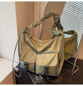 Detail of olive green nylon tote bag featuring front utility pockets with plastic buckles