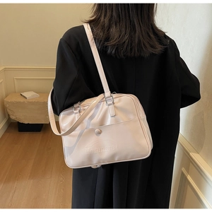 Detail of glossy pink patent leather shoulder bag featuring Ioromoro embossed logo