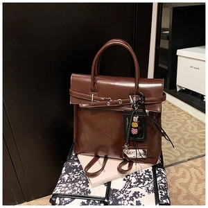 Gros plan détaillé du sac à dos en cuir brillant marron foncé avec boucle vintage
