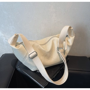 Detailed macro view of cream dumpling bag with pleated texture and silver buckle