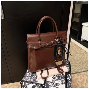 Détail du sac cabas en simili cuir marron foncé avec finition brillante et breloques