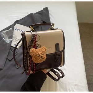 Detailansicht des Vintage-Rucksacks in Beige und Braun mit Plüschbär und Metallgriff