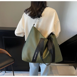 Vue détaillée du sac cabas en nylon vert olive avec large bandoulière à lettrage blanc