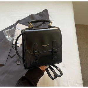Details des schwarzen Retro-Lederrucksacks mit goldenen Beschlägen und Schriftzug
