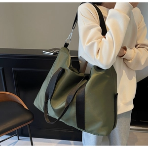 Détail du sac fourre-tout en nylon vert armée avec anses noires et bandoulière