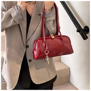 Detail of vintage red patent leather bowling bag with gold clasp and letter embossing