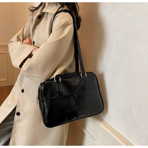 Chic black glossy leather underarm bag styled with a beige trench coat for a retro look