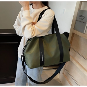Détail du sac de voyage en nylon vert armée avec poignées noires et bandoulière amovible