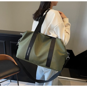 Détail du sac en nylon vert olive montrant la sangle robuste avec imprimé LOVE blanc