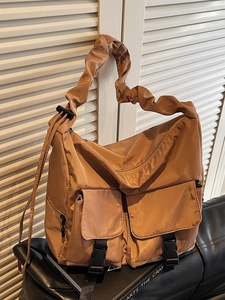 Brown nylon tote bag with pocket details and cloud-style ruched shoulder strap