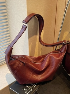 Fashionable burgundy leather crescent bag with adjustable wide strap for women