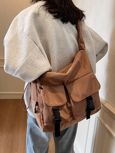 Large caramel messenger bag with utility pockets and tactical buckles for women