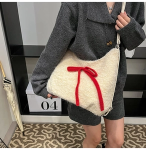 Close-up of the plush cream crossbody bag featuring a vibrant red bow and soft texture