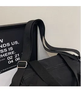Dettaglio della borsa tote nera in tela con tracolla regolabile e texture del materiale