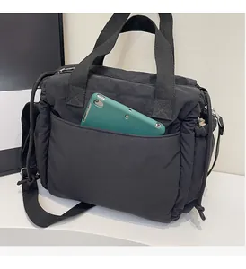 Dettaglio della borsa tote in nylon trapuntato nero con tasca frontale per un tablet pc
