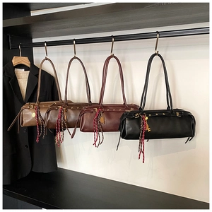 Détail de sacs baguette vintage en quatre couleurs avec des pompons tressés élégants