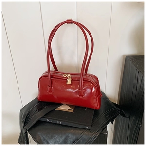 Macro shot of red glossy patent leather bowling bag with gold padlock and zipper details