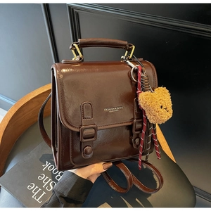 Nahaufnahme eines dunkelbraunen Retro-Rucksacks aus Kunstleder mit glänzendem Finish