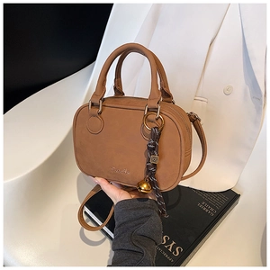 Brown faux leather crossbody bag with golden bell charm and braided rope detail