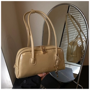 Macro shot of beige bowling bag with gold hardware, leather texture and mirror reflection
