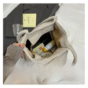 Macro view of beige corduroy tote bag interior showing large capacity for tablets and cosmetics