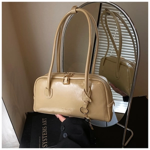 Detail view of beige PU leather bowling bag with embossed logo and padlock charm