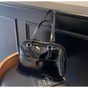 Close-up of vintage black glossy leather bag showing the Noronoro embossed logo detail