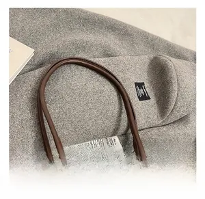 Détail du sac cabas en cuir marron foncé avec fines anses rondes et foulard décoratif