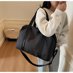 Détail d'un grand sac de sport en nylon noir avec de larges sangles et des boucles argentées